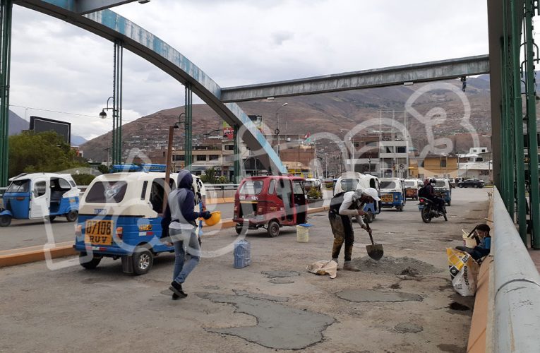 Venezolanos parchan huecos en puente San Sebastián